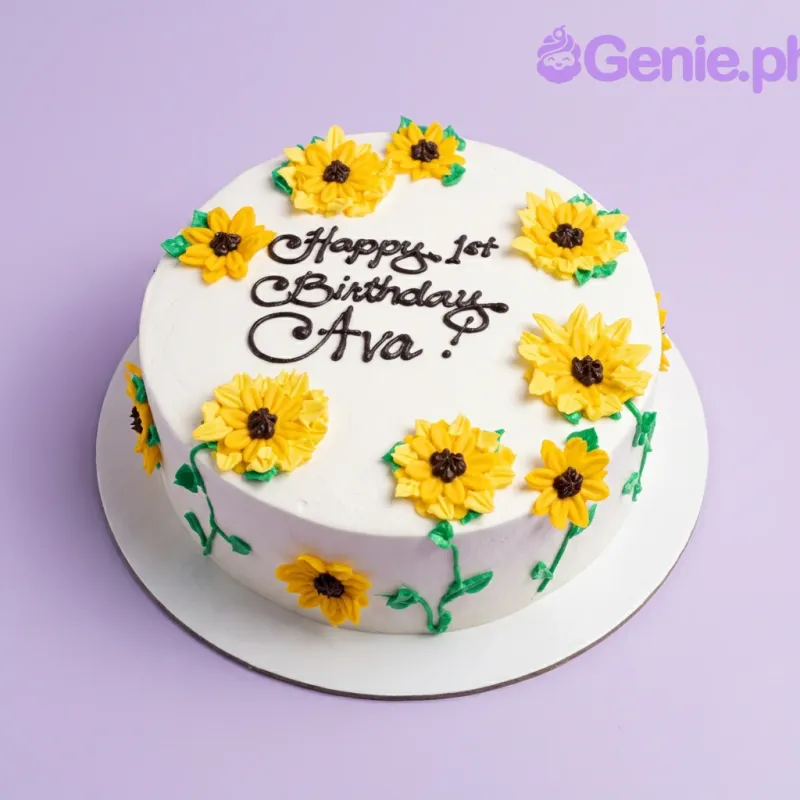 A white 1-tier round cake themed with sunflowers, featuring yellow piped icing sunflowers, green leaves, and black text. A white 1-tier round cake themed with sunflowers, featuring yellow piped icing sunflowers, green leaves, and black text.
