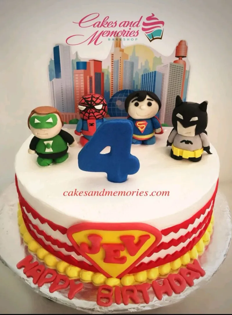 Superhero themed birthday cake with fondant figures of Green Lantern, Spiderman, Superman, and Batman on a white icing base. Superhero themed birthday cake with fondant figures of Green Lantern, Spiderman, Superman, and Batman on a white icing base.