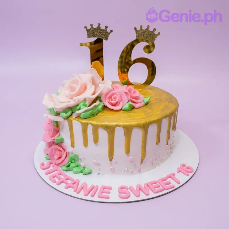 A white, gold, and pink 1-tier Sweet 16 cake, featuring a gold number 16 crown topper, gold drip, pink roses, and a pink message. A white, gold, and pink 1-tier Sweet 16 cake, featuring a gold number 16 crown topper, gold drip, pink roses, and a pink message.