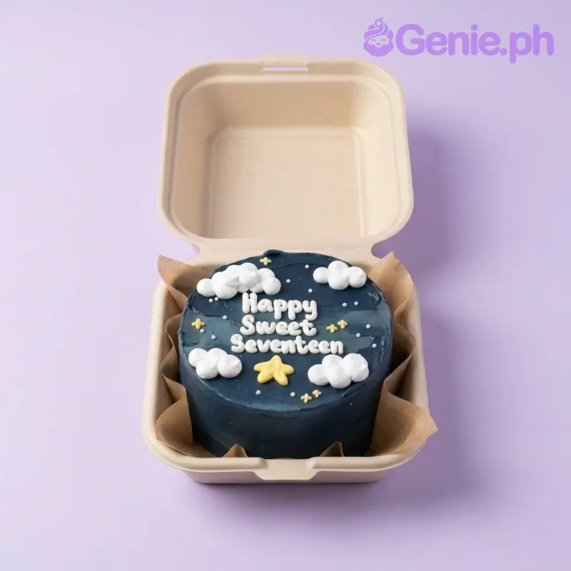 A navy blue bento cake themed for Sweet Seventeen, featuring white icing clouds, yellow stars, and 'Happy Sweet Seventeen' message. A navy blue bento cake themed for Sweet Seventeen, featuring white icing clouds, yellow stars, and 'Happy Sweet Seventeen' message.