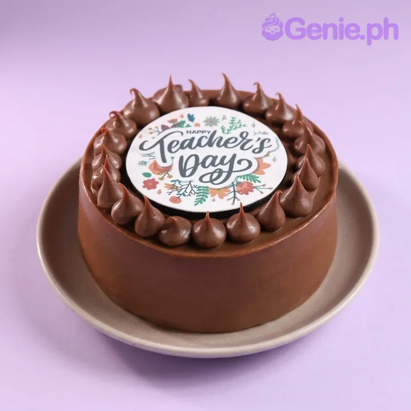 A brown 1 Tier cake for Teacher's Day, featuring a circular 'Happy Teacher's Day' printout and chocolate icing dollops. A brown 1 Tier cake for Teacher's Day, featuring a circular 'Happy Teacher's Day' printout and chocolate icing dollops.