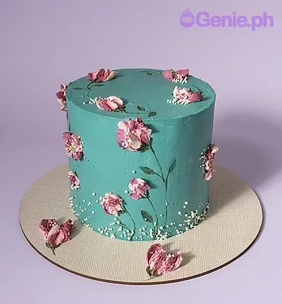 A teal and white 1-tier cake themed around Teal Floral, featuring pink palette knife icing flowers and white pearl sprinkles at the base. A teal and white 1-tier cake themed around Teal Floral, featuring pink palette knife icing flowers and white pearl sprinkles at the base.