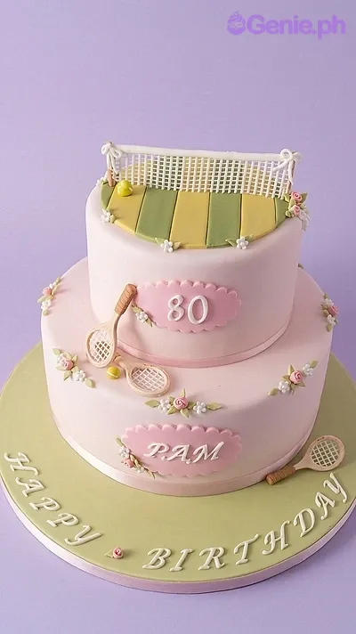 A pink and green 2-tier fondant cake themed around tennis, featuring a gumpaste net, tennis rackets, and floral accents. A pink and green 2-tier fondant cake themed around tennis, featuring a gumpaste net, tennis rackets, and floral accents.