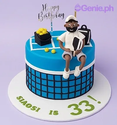 A blue 1-tier fondant cake themed around Tennis, featuring a 3D fondant tennis player, tennis balls, and a net design. A blue 1-tier fondant cake themed around Tennis, featuring a 3D fondant tennis player, tennis balls, and a net design.