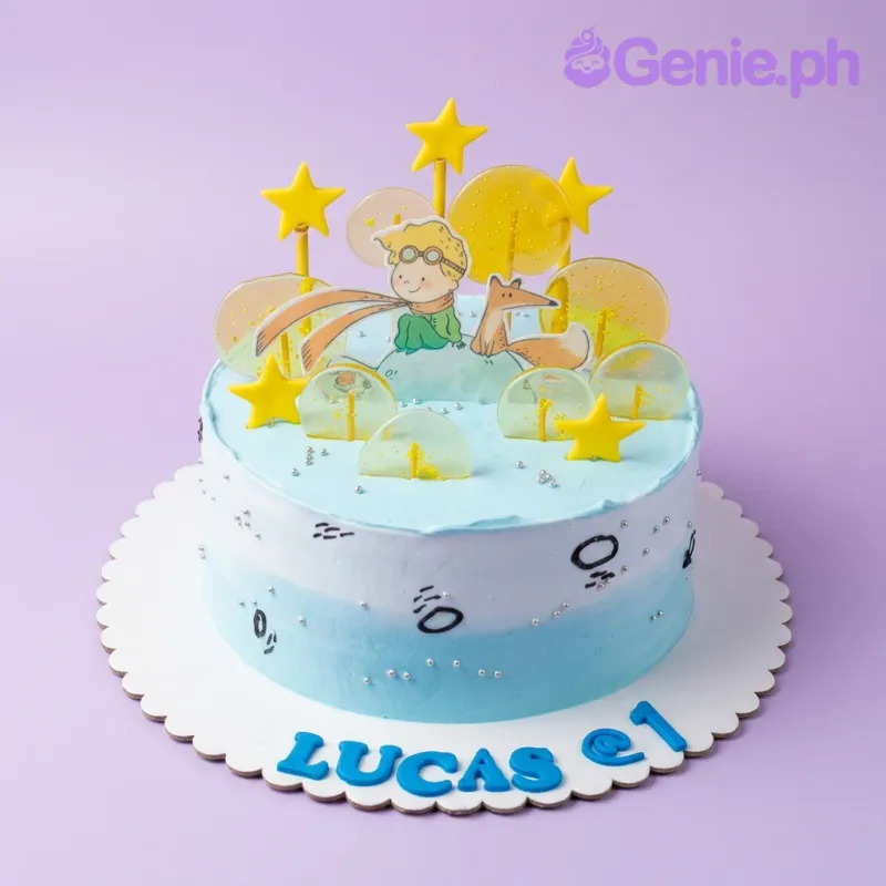 The Little Prince themed cake with light blue and white icing, featuring a fox and prince printout, yellow stars, and clear isomalt lollipops. The Little Prince themed cake with light blue and white icing, featuring a fox and prince printout, yellow stars, and clear isomalt lollipops.