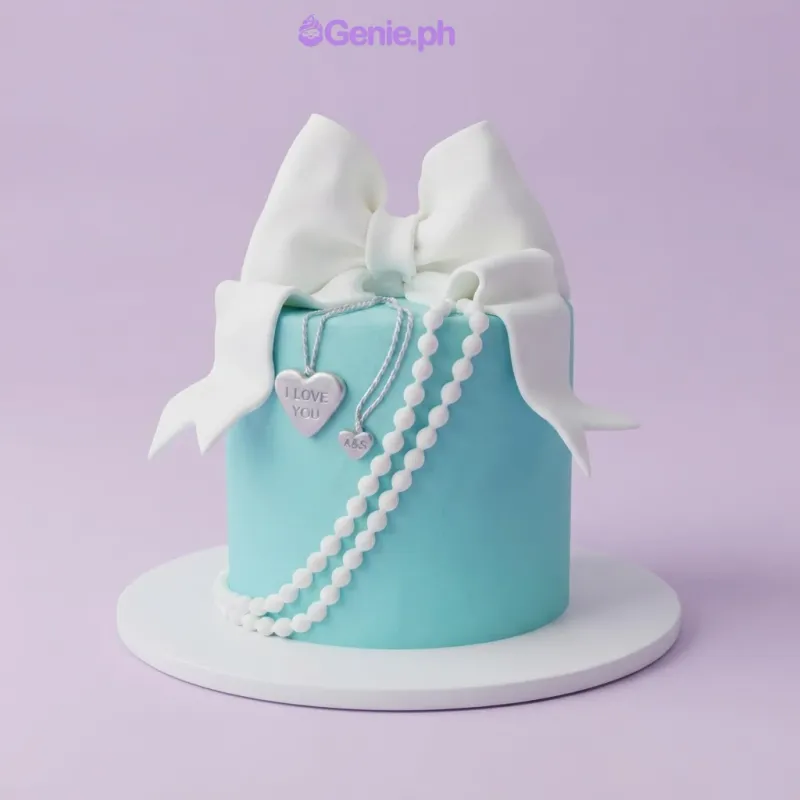 Teal 1-tier fondant cake with a large white fondant bow, silver heart pendants, and a string of white pearls Teal 1-tier fondant cake with a large white fondant bow, silver heart pendants, and a string of white pearls