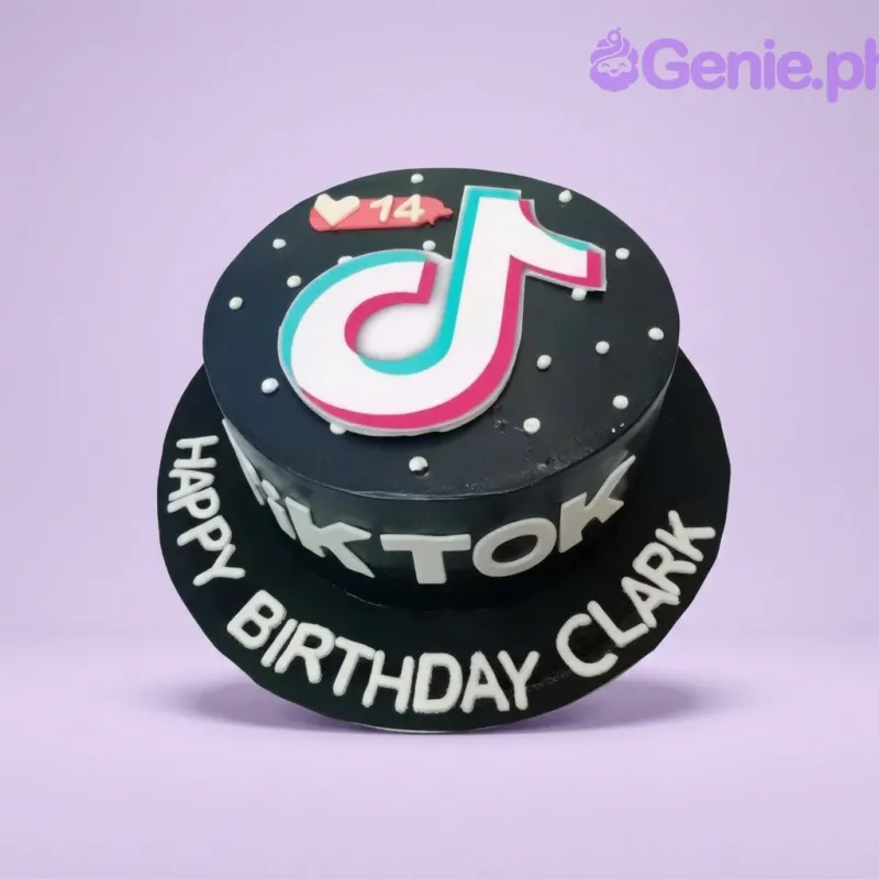A black and white 1 Tier cake themed around TikTok, featuring a large TikTok logo and a notification bubble topper, with white icing text and dots. A black and white 1 Tier cake themed around TikTok, featuring a large TikTok logo and a notification bubble topper, with white icing text and dots.