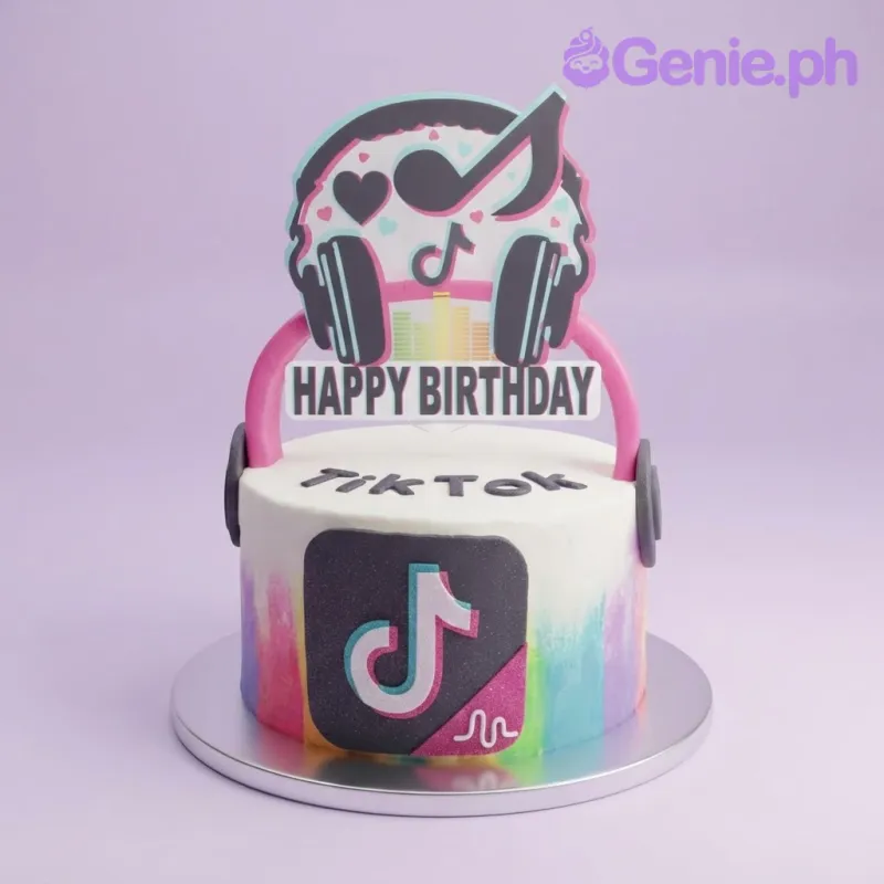 White 1-tier soft icing cake with colorful watercolor strokes, a TikTok headphone printout, and a black fondant logo White 1-tier soft icing cake with colorful watercolor strokes, a TikTok headphone printout, and a black fondant logo