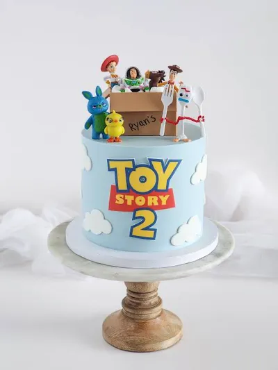 Sky blue 1 tier cake with smooth soft icing, Toy Story theme, and plastic character figurines with fondant clouds Sky blue 1 tier cake with smooth soft icing, Toy Story theme, and plastic character figurines with fondant clouds