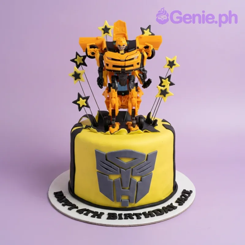 A yellow and black 1 Tier Fondant cake themed around Transformers Bumblebee, featuring a large robot toy and an Autobot logo. A yellow and black 1 Tier Fondant cake themed around Transformers Bumblebee, featuring a large robot toy and an Autobot logo.