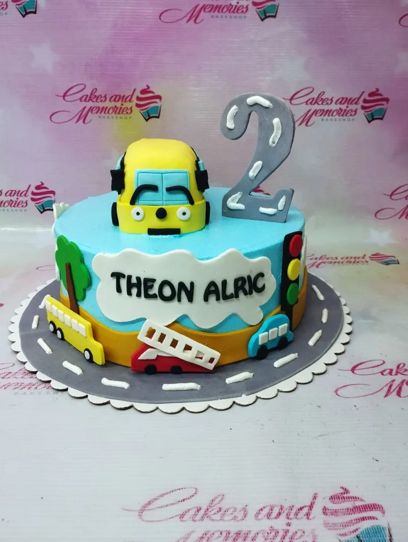 Blue and yellow transportation themed birthday cake with a bus topper, traffic light, and road design for a 2nd birthday. Blue and yellow transportation themed birthday cake with a bus topper, traffic light, and road design for a 2nd birthday.
