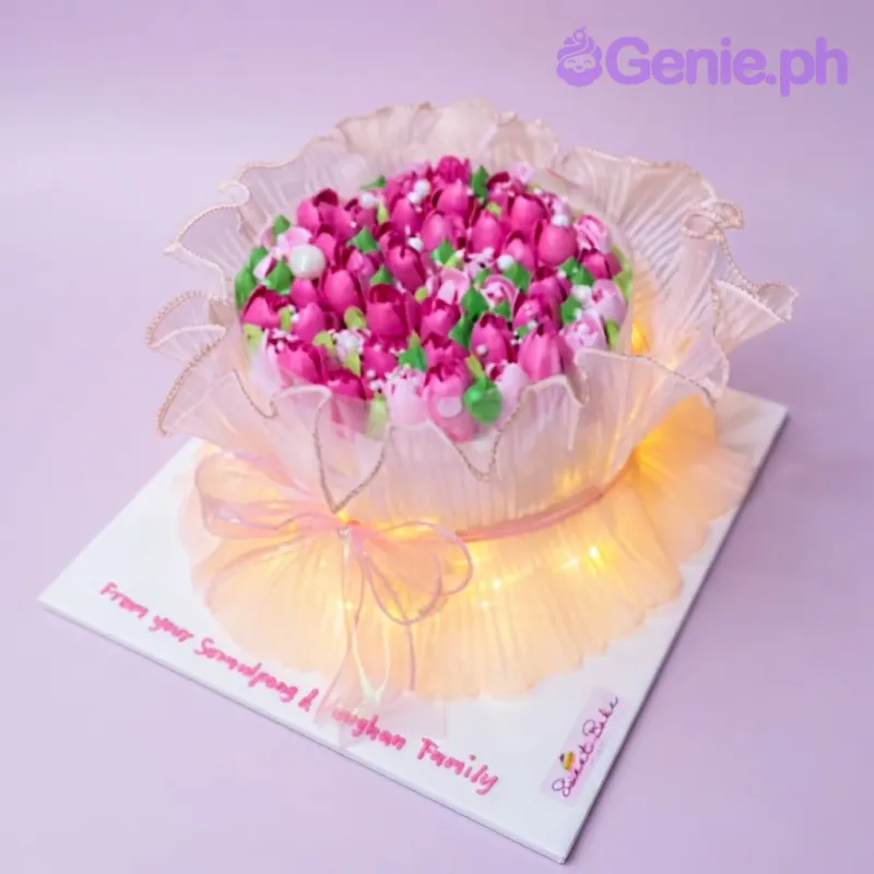 White 1-tier cake with smooth soft icing, pink and purple tulip flowers, and a sheer pink ribbon bow White 1-tier cake with smooth soft icing, pink and purple tulip flowers, and a sheer pink ribbon bow