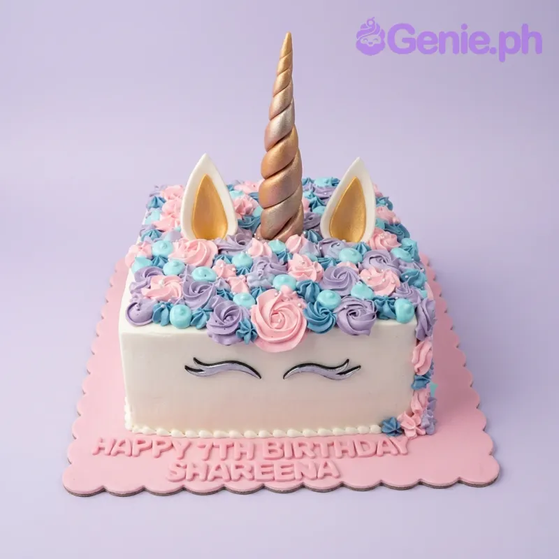 A white square cake themed around Unicorn, featuring a gold horn, ears, colorful rosettes, and a pink message. A white square cake themed around Unicorn, featuring a gold horn, ears, colorful rosettes, and a pink message.