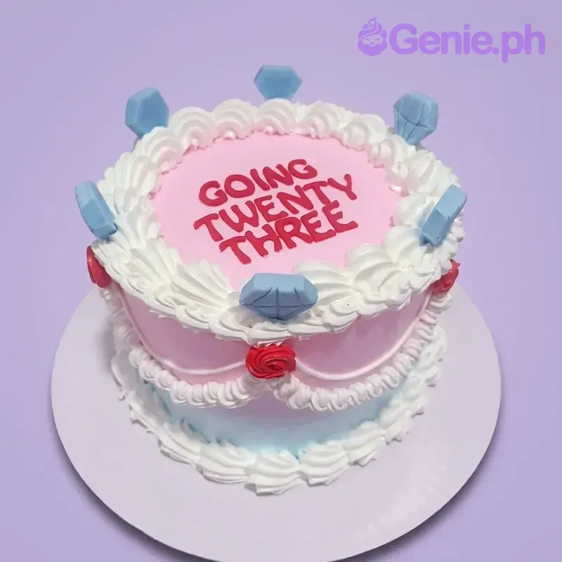 A pink and light blue 1-tier Vintage Birthday cake with blue diamond toppers, red roses, and white icing ruffles. A pink and light blue 1-tier Vintage Birthday cake with blue diamond toppers, red roses, and white icing ruffles.