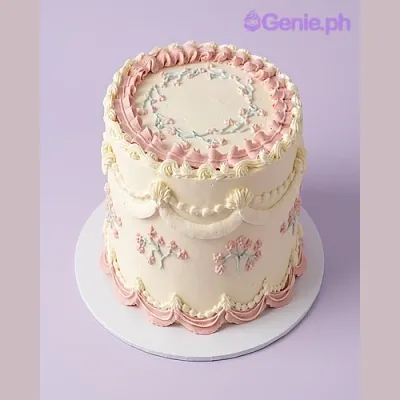 White 1-tier cake with pink piped borders and floral piping design