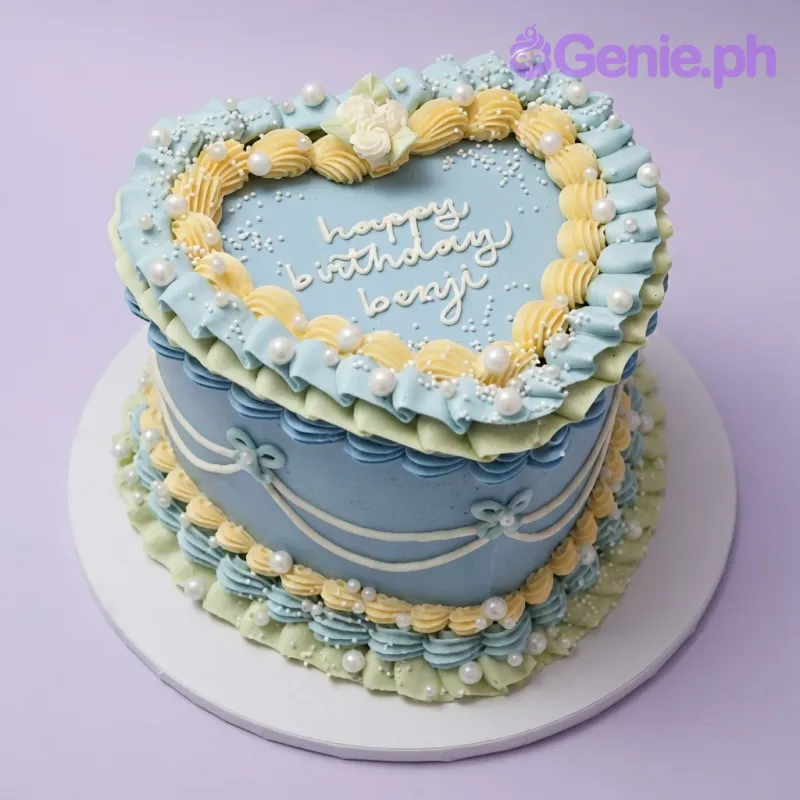 Sky blue 2-tier birthday cake with soft icing, piped yellow shell borders, and a piped cream rose
