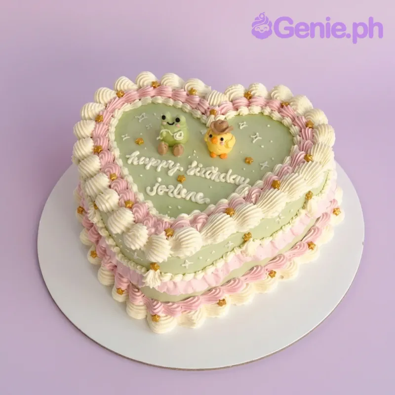 Heart shaped light green vintage cake with pink and white ruffles, gold stars, and fondant frog and chick figures. Heart shaped light green vintage cake with pink and white ruffles, gold stars, and fondant frog and chick figures.