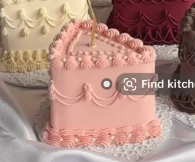 Soft pink 1-tier cake with smooth icing, piped shell borders, and white sugar pearls