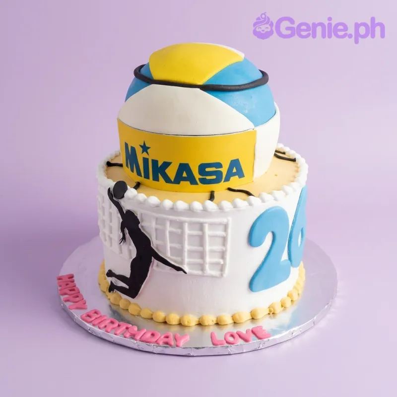 A yellow and white 2-tier cake themed around Volleyball, featuring a Mikasa volleyball, blue number 20, and player silhouette. A yellow and white 2-tier cake themed around Volleyball, featuring a Mikasa volleyball, blue number 20, and player silhouette.