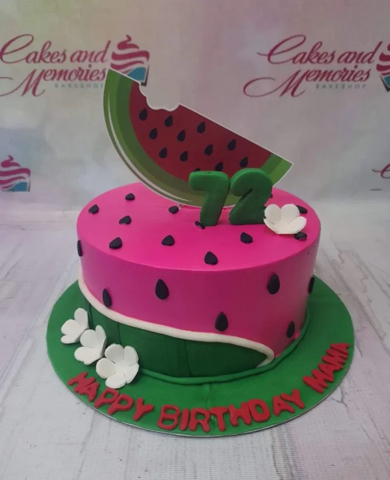 A pink, black, green, and white 1 Tier cake themed around Watermelon, featuring a large watermelon slice, number 72, black seeds, green rind, and white flowers. A pink, black, green, and white 1 Tier cake themed around Watermelon, featuring a large watermelon slice, number 72, black seeds, green rind, and white flowers.