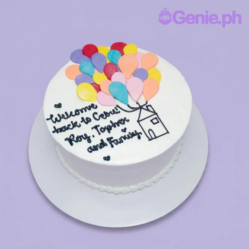 A white 1-tier Welcome Back cake with colorful 2D fondant balloons, a piped house illustration, and a personalized message. A white 1-tier Welcome Back cake with colorful 2D fondant balloons, a piped house illustration, and a personalized message.