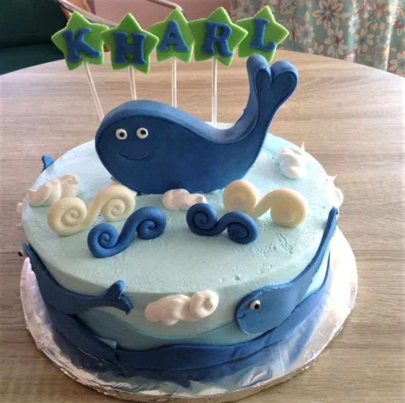 Light blue whale themed birthday cake with a large blue fondant whale topper and white icing waves. Light blue whale themed birthday cake with a large blue fondant whale topper and white icing waves.