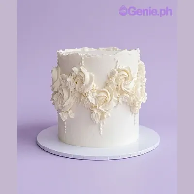 White single-tier cake with piped white rosettes and pearl dragees White single-tier cake with piped white rosettes and pearl dragees