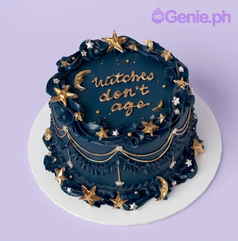 A navy blue 1-tier cake themed around Witchy Minimalist, featuring gold icing text "Witches don't age" and gold and silver star and moon decorations. A navy blue 1-tier cake themed around Witchy Minimalist, featuring gold icing text "Witches don't age" and gold and silver star and moon decorations.