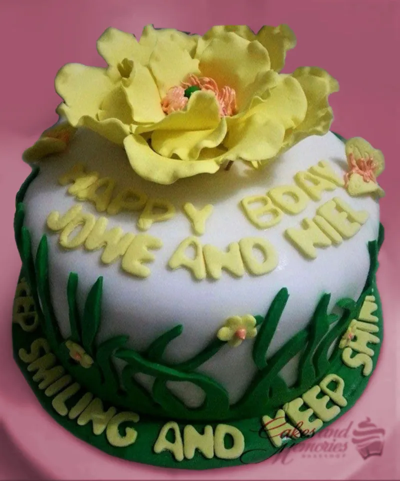 A white, yellow, and green 1 Tier Fondant cake themed around a Yellow Flower Garden, featuring a large yellow gumpaste flower and green grass accents with yellow text. A white, yellow, and green 1 Tier Fondant cake themed around a Yellow Flower Garden, featuring a large yellow gumpaste flower and green grass accents with yellow text.
