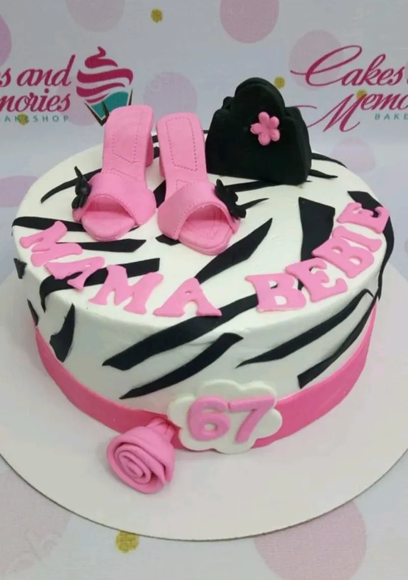 White fondant cake with black zebra stripes, pink high heels, a black handbag, and a pink rose decoration. White fondant cake with black zebra stripes, pink high heels, a black handbag, and a pink rose decoration.