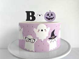 A photo of a Boo themed cake. It is a custom colored 1 Tier cake decorated with a 'Boo' message, a letter B and 'o' dots, a purple pumpkin, ghosts with various expressions, and purple dot sprinkles. A photo of a Boo themed cake. It is a custom colored 1 Tier cake decorated with a 'Boo' message, a letter B and 'o' dots, a purple pumpkin, ghosts with various expressions, and purple dot sprinkles.