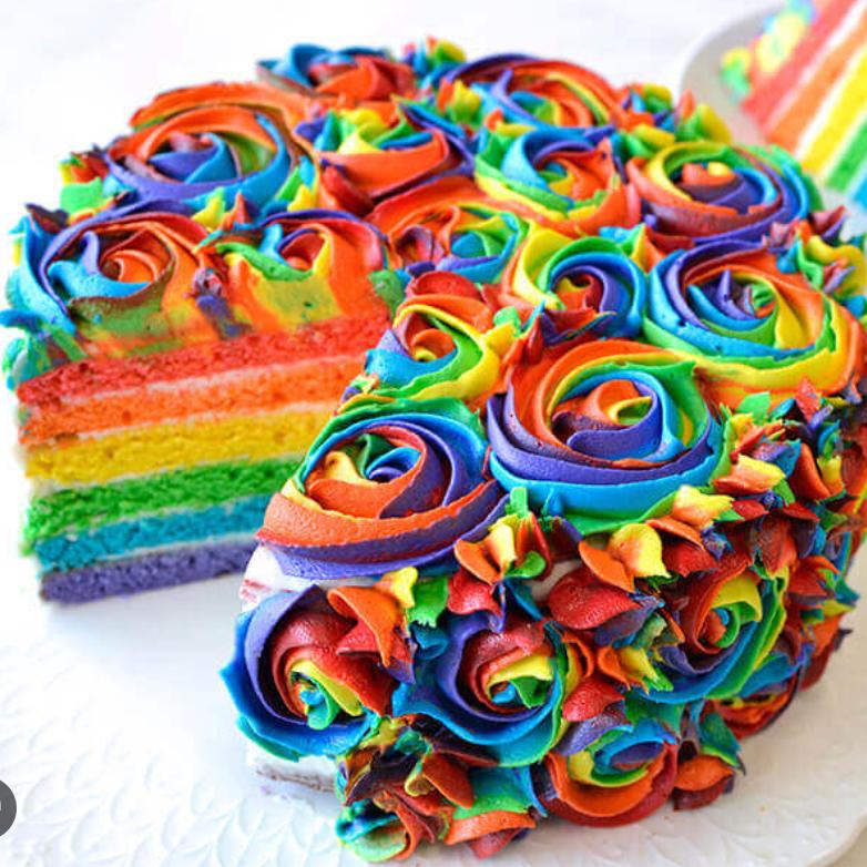 Vibrant rainbow rosette cake with multi-colored icing swirls and colorful layered cake interior.