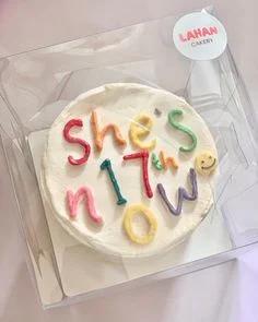 White bento cake with colorful 3D icing letters reading 'she's 17th now' and a small yellow smiley face.