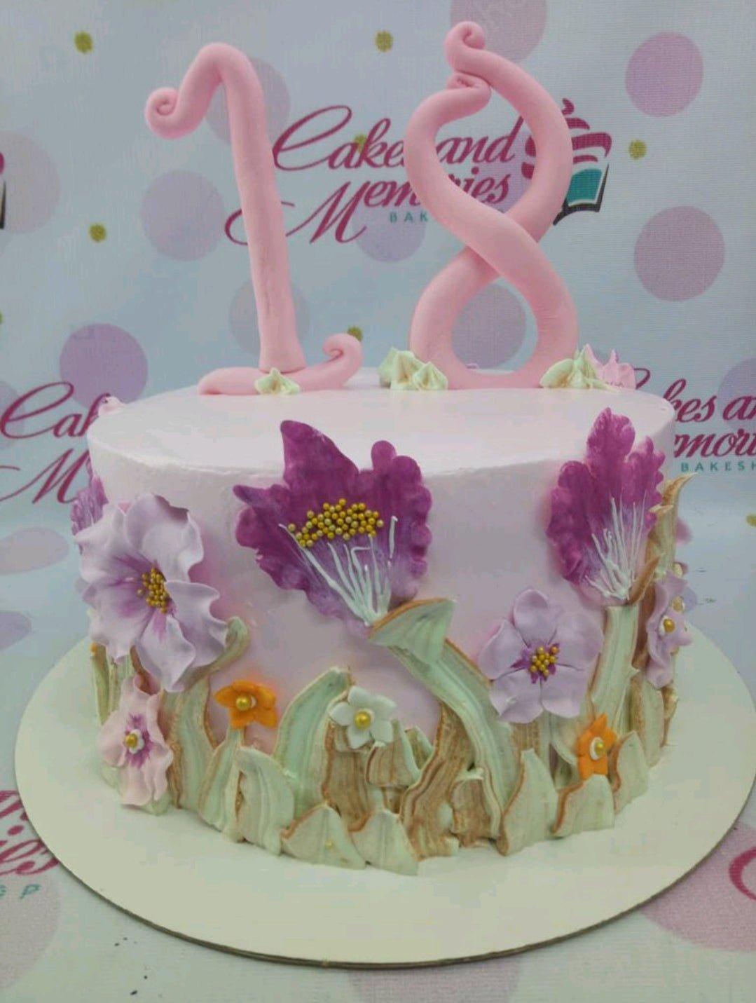 Pink 18th birthday cake with palette knife icing flowers and large pink fondant number 18 topper.