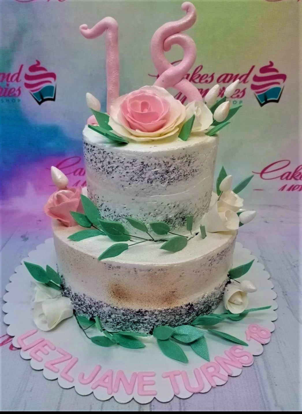 Two-tier semi-naked chocolate cake with pink and white gumpaste roses, green leaves, and a pink number 18 topper.