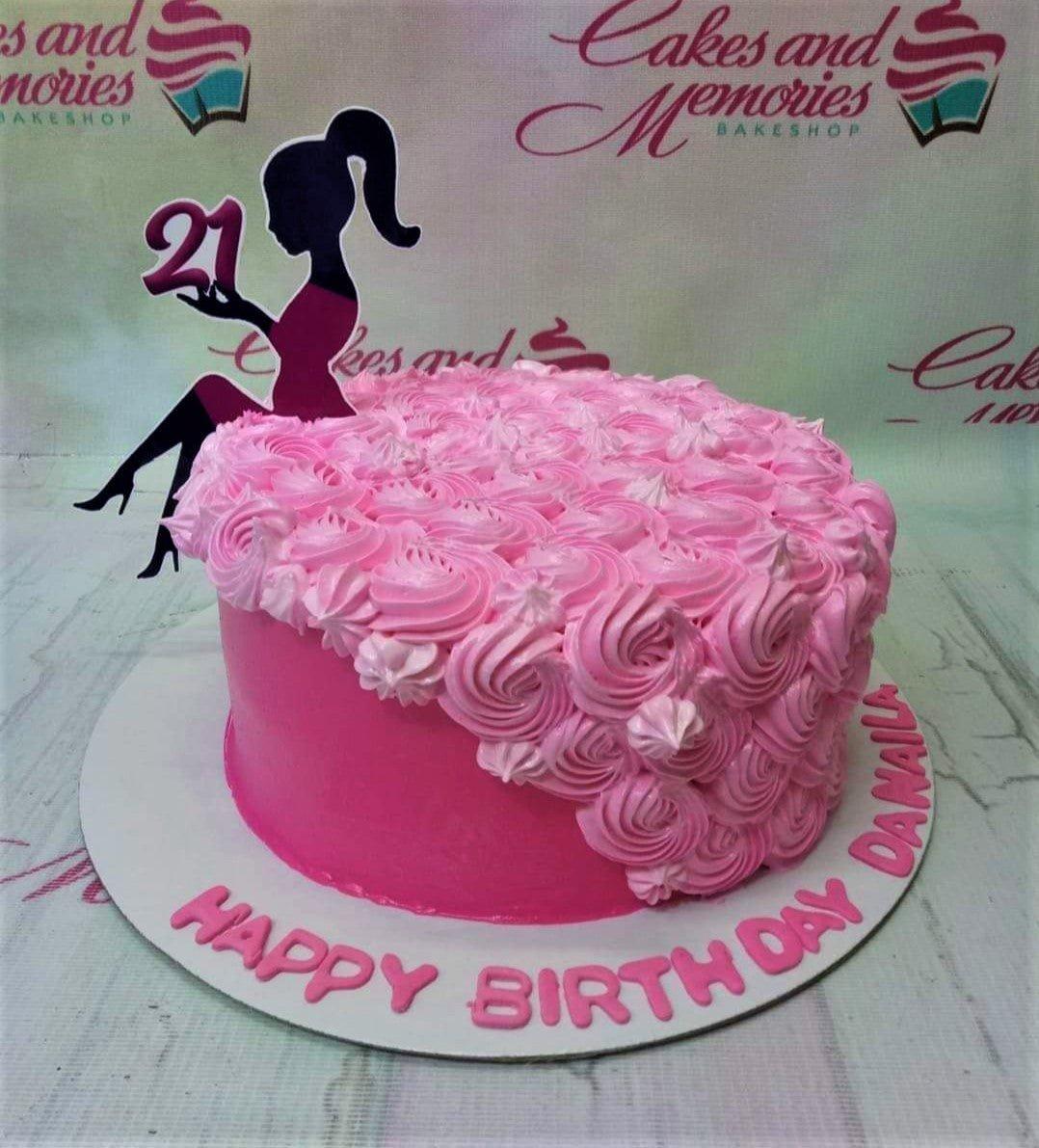 Pink 21st birthday cake with a black silhouette woman topper and pink icing rosettes covering the top and side.