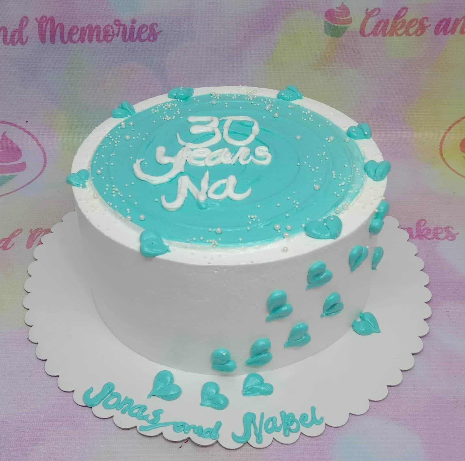 White and teal minimalist birthday cake with piped hearts and 30 Years Na message