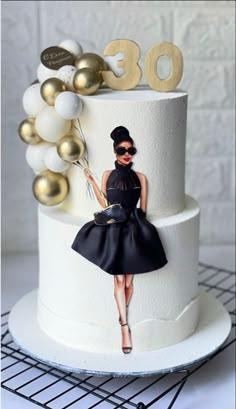 Elegant white 2-tier birthday cake featuring a stylish woman printout with a 3D fondant dress and gold balloon cluster.