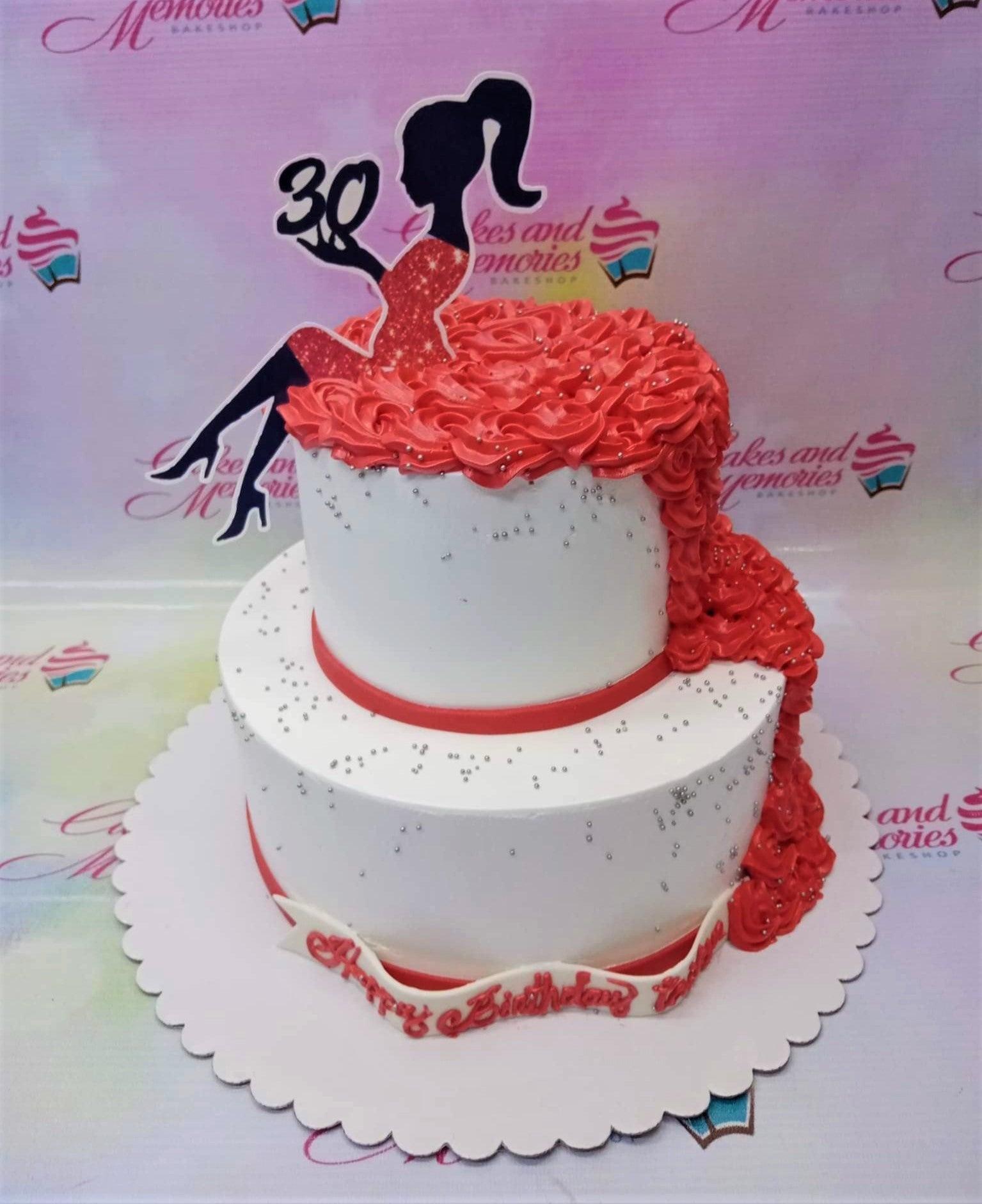 Elegant 2-tier white cake with red icing rosettes cascading down the side and a silhouette topper of a woman celebrating her 30th birthday.