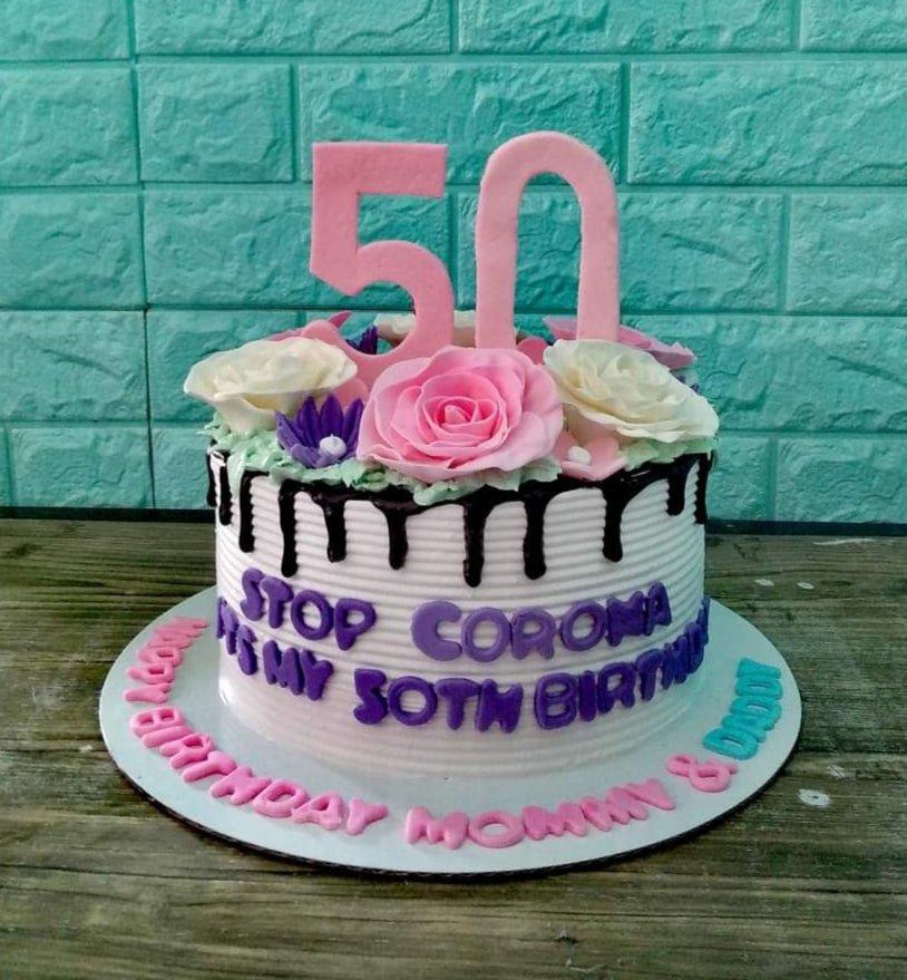 White 1-tier 50th birthday cake with pink and white edible roses, chocolate drip, and purple gumpaste letters.