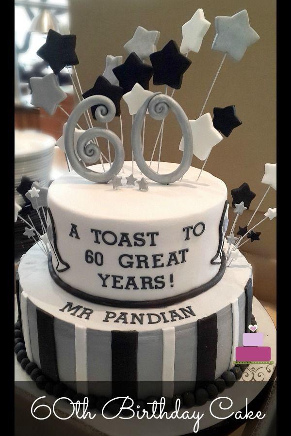 Two-tier black and white striped 60th birthday cake with silver and black fondant stars on wires and a large silver 60 topper.
