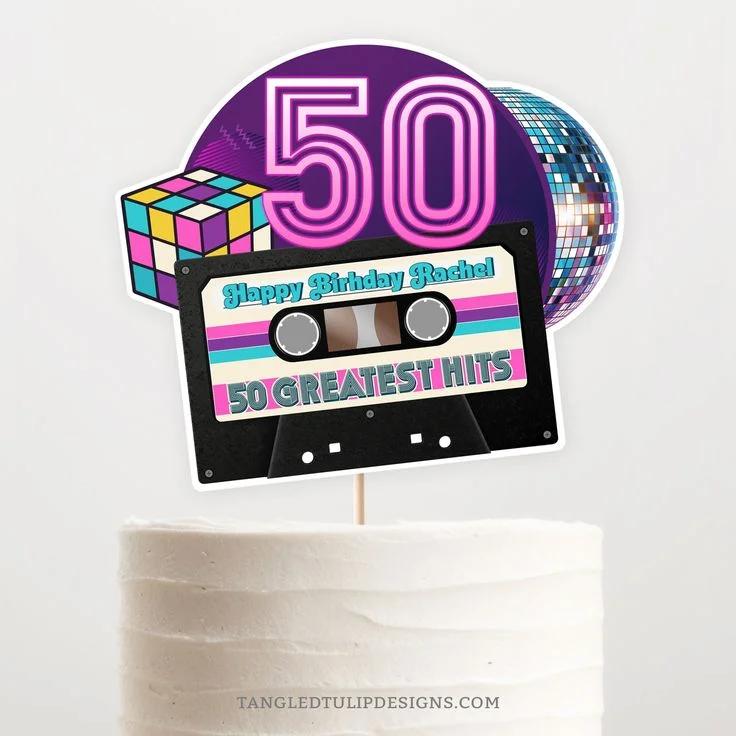 Retro 80s themed white cake with a large cassette tape and disco ball printout topper for a 50th birthday celebration.