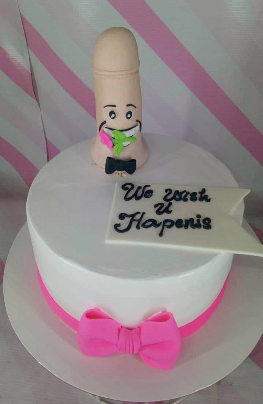 White minimalist cake with a humorous 3D fondant figure and a pink bow border.