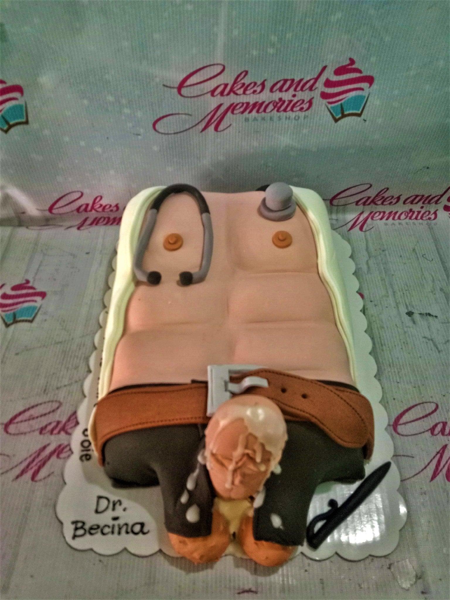 A humorous adult-themed rectangle fondant cake shaped like a muscular male torso with a stethoscope and a small figure at the bottom.