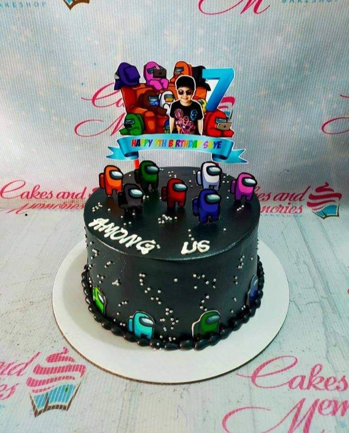 Black Among Us themed birthday cake with colorful character printouts and silver dragees.