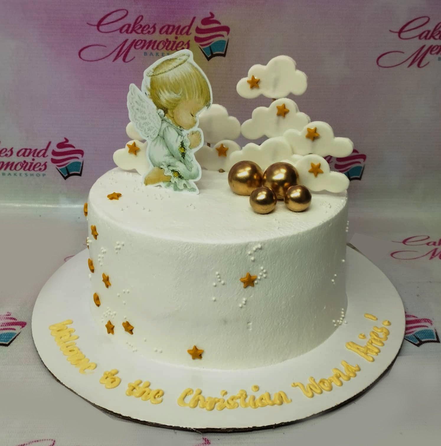 White 1-tier baptism cake with a praying angel printout, white fondant clouds, gold stars, and gold spheres.
