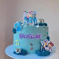 Teal blue anime themed birthday cake for Hughie with character printouts, music notes, and disco balls.