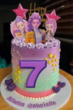 Purple and green gradient birthday cake with anime character printouts, a large purple number 7, and yellow stars.