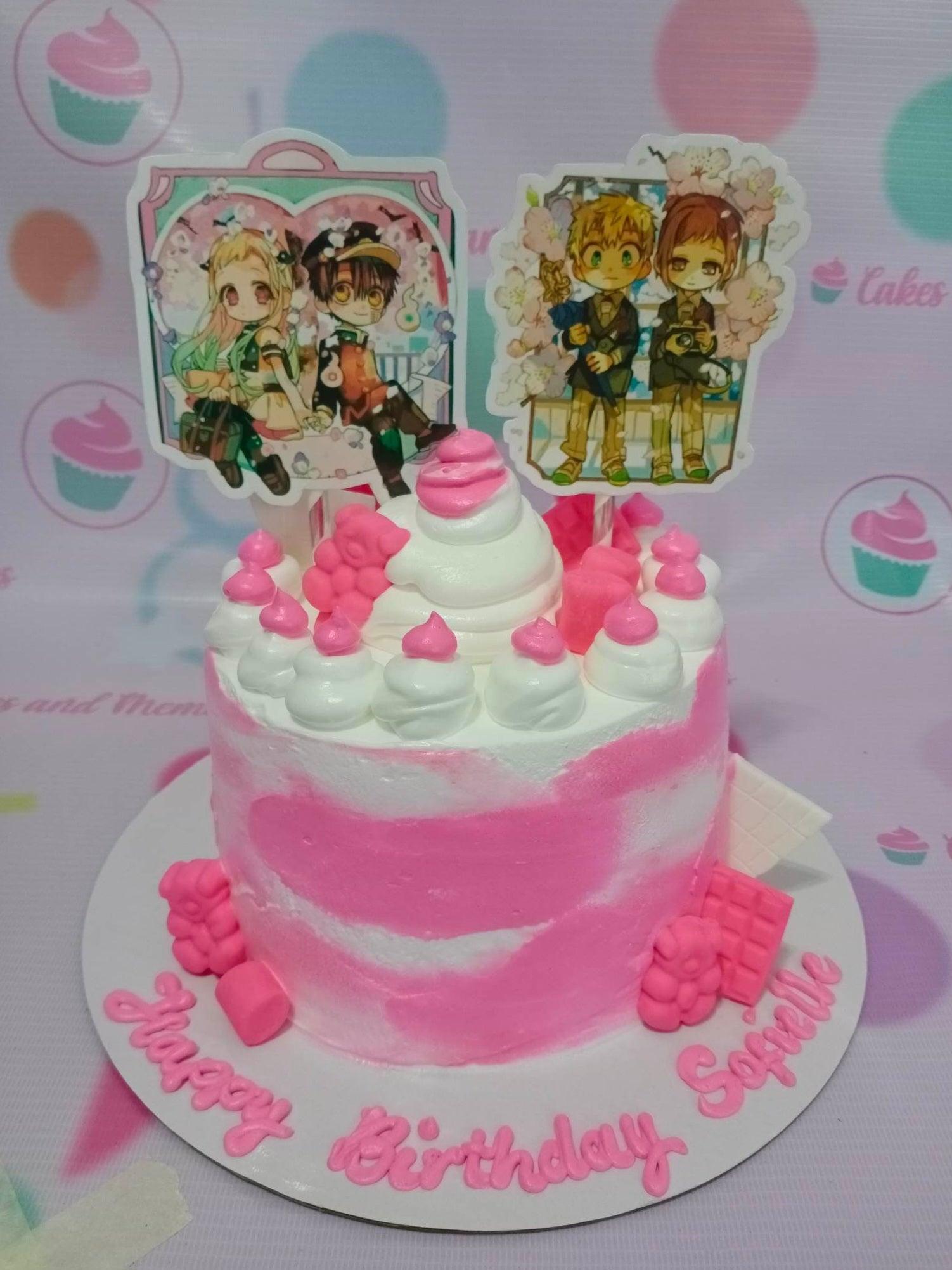 Pink and white marbled cake with anime character printouts, pink icing dollops, and pink chocolate bar decorations.