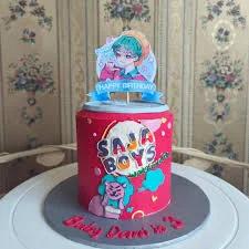 Red anime themed birthday cake with a blue-haired character printout topper and colorful Saja Boys logo on the side.